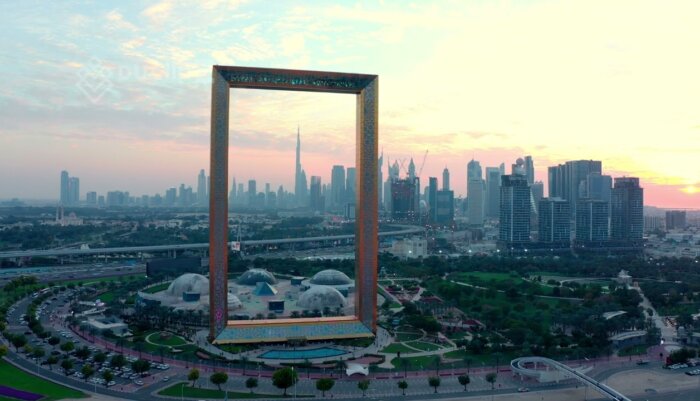 Smooth Drone Flyover of Dubai Frame with Warm Sunset Glow - Dubai Frame drone footage