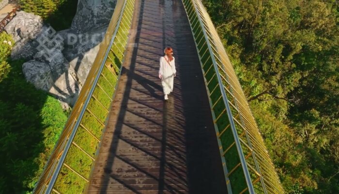 Cinematic 4K Drone Views of Da Nang Golden Bridge Amid Lush Greenery with Model walking